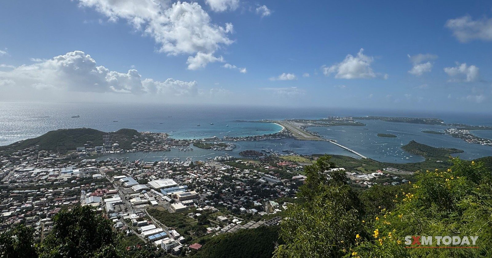 The west of Sint Maarten from the hills: houses below, the airport runway, Simpson Bay and the lagoon beyond.
