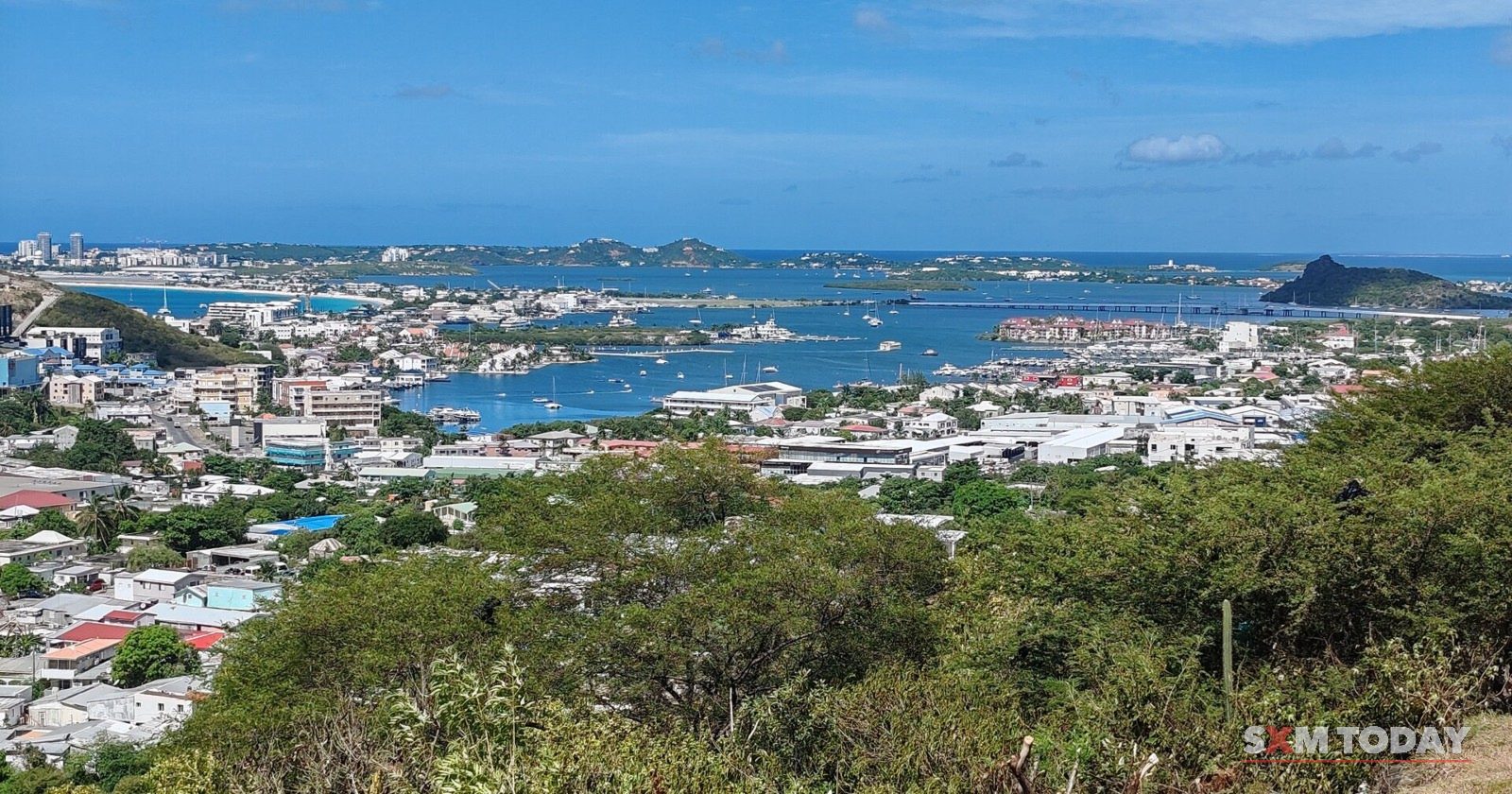 Houses of Cole Bay and Simpson Bay spread below Cole Hill, with the lagoon and the sea beyond.