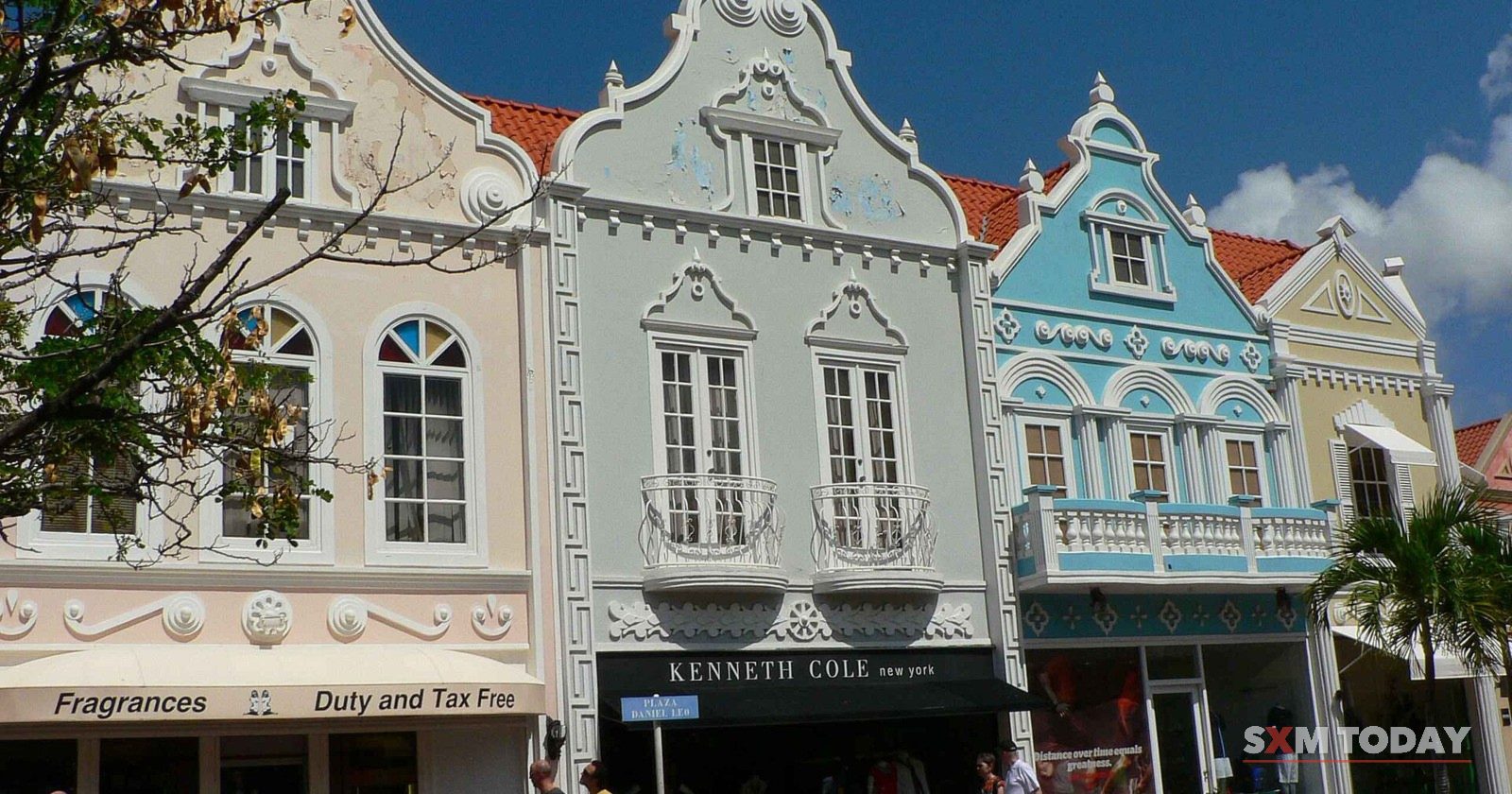 Pastel Dutch-style shop buildings with ornate gables on a street in Oranjestad, Aruba.