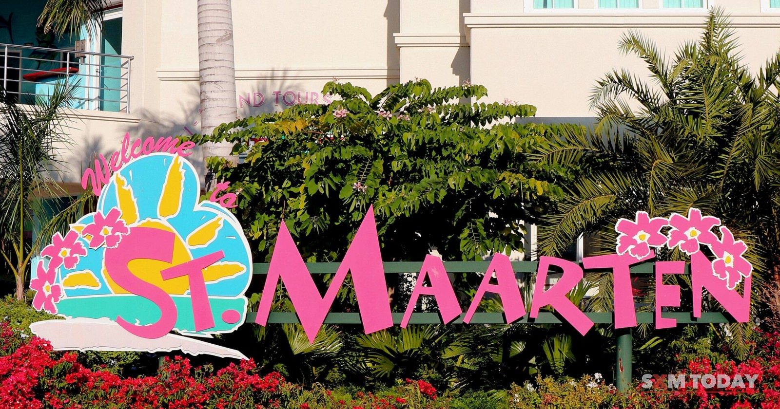 The colourful 'Welcome to St. Maarten' sign above a bed of red flowers at the Philipsburg cruise facility.