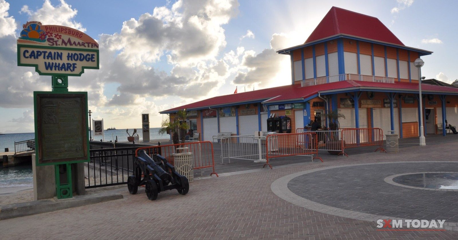 Captain Hodge Wharf on the Philipsburg waterfront, with its sign, an old cannon and a red-roofed pavilion.