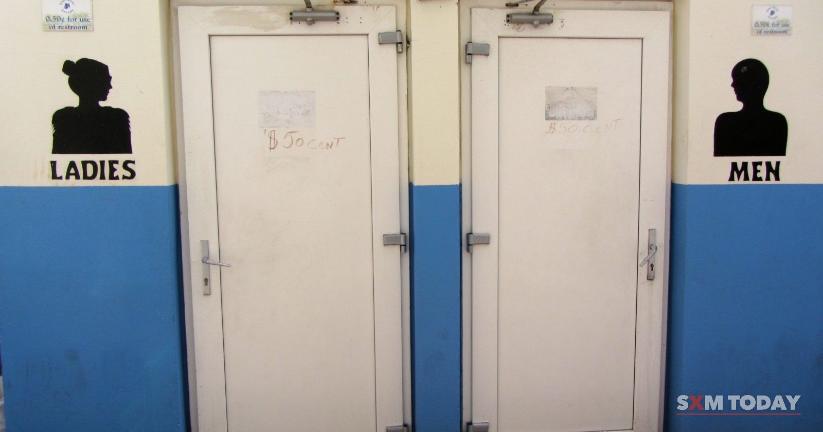 Two white doors in a blue-and-cream wall are marked Ladies and Men with silhouette signs.
