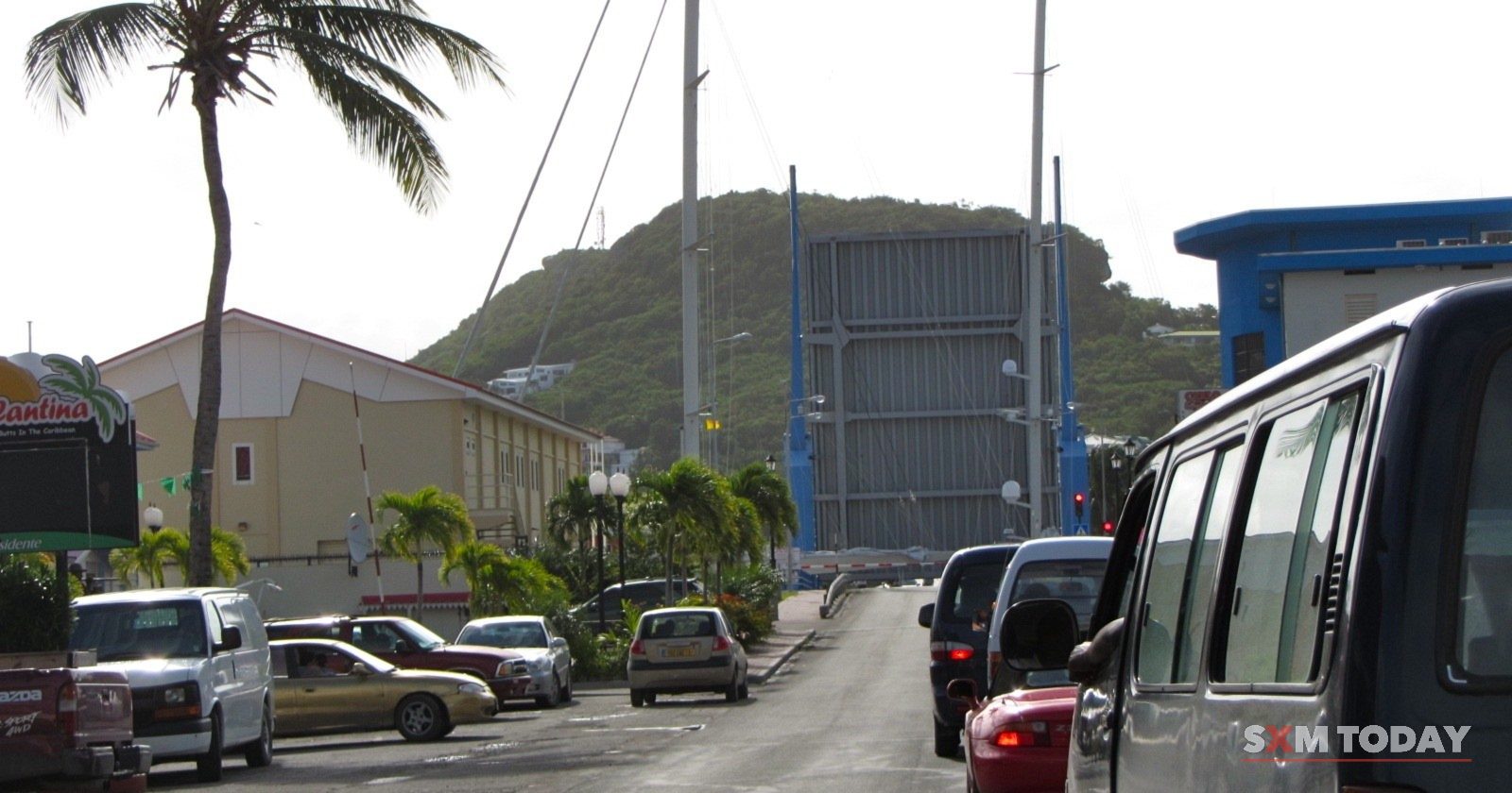 The Simpson Bay bridge raised for boats while cars wait on the road.