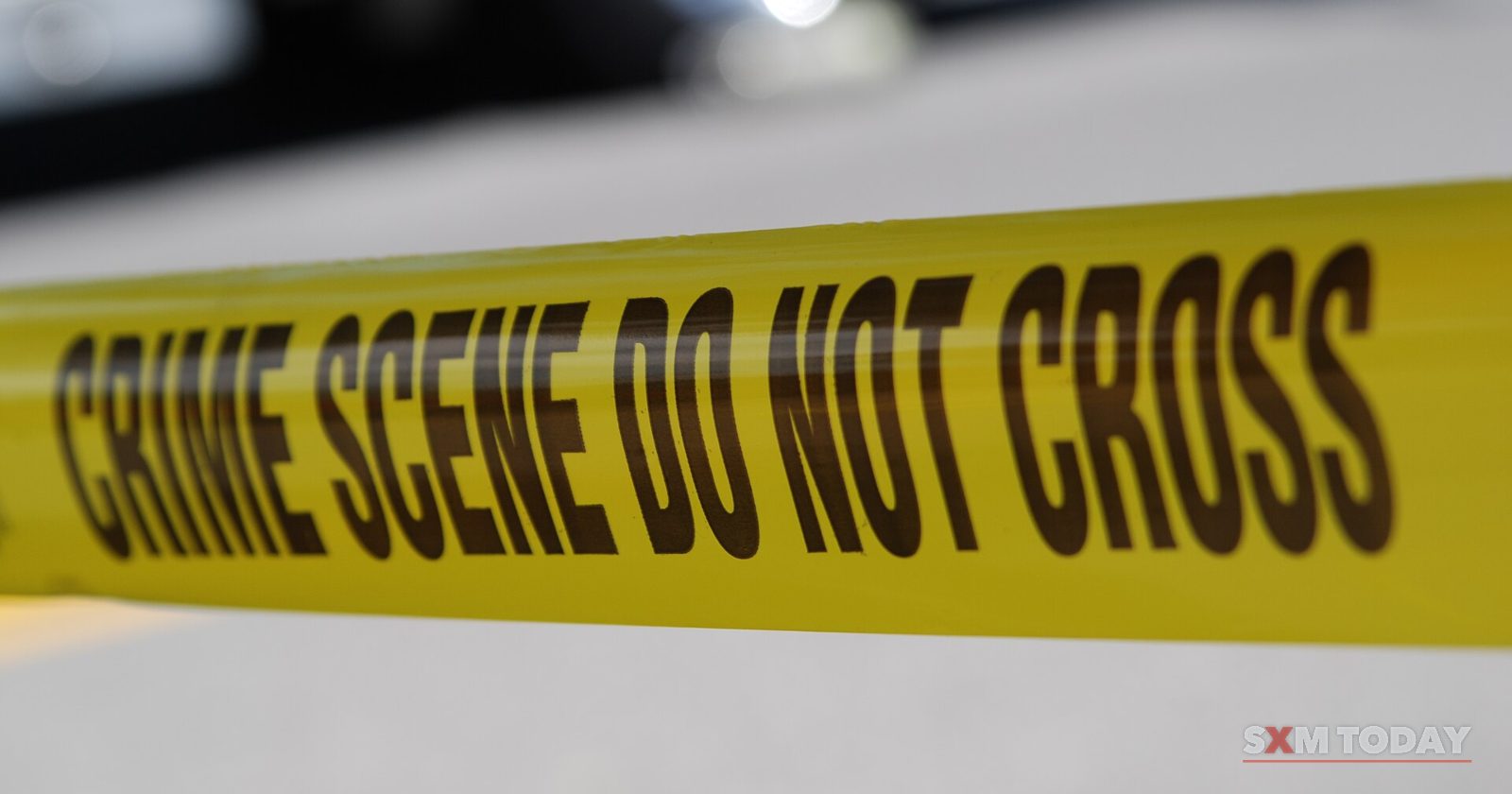 A strip of yellow tape reading Crime Scene Do Not Cross stretched across the frame.
