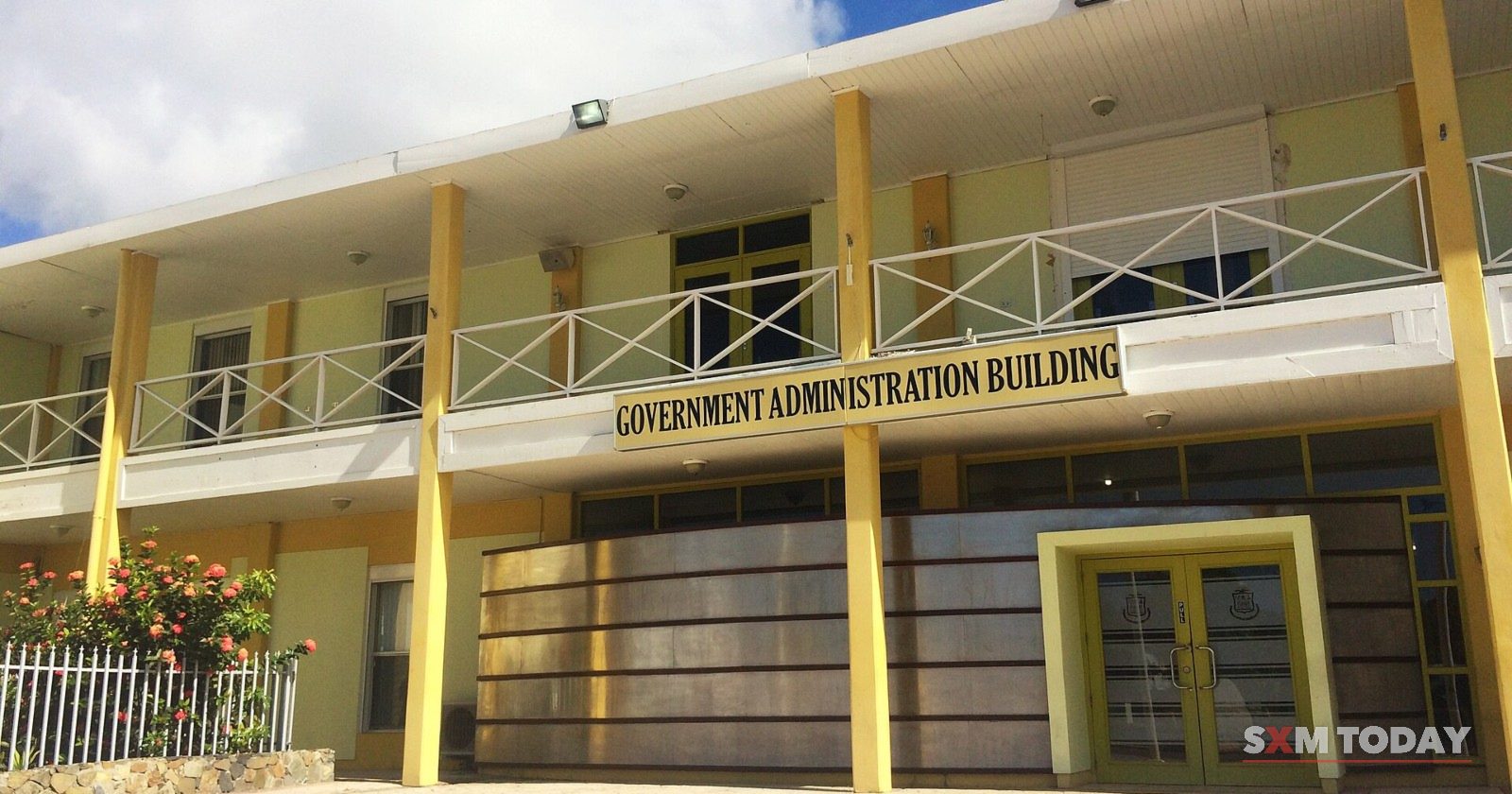 The front of the Government Administration Building in Philipsburg, yellow and white, with its name above the entrance.
