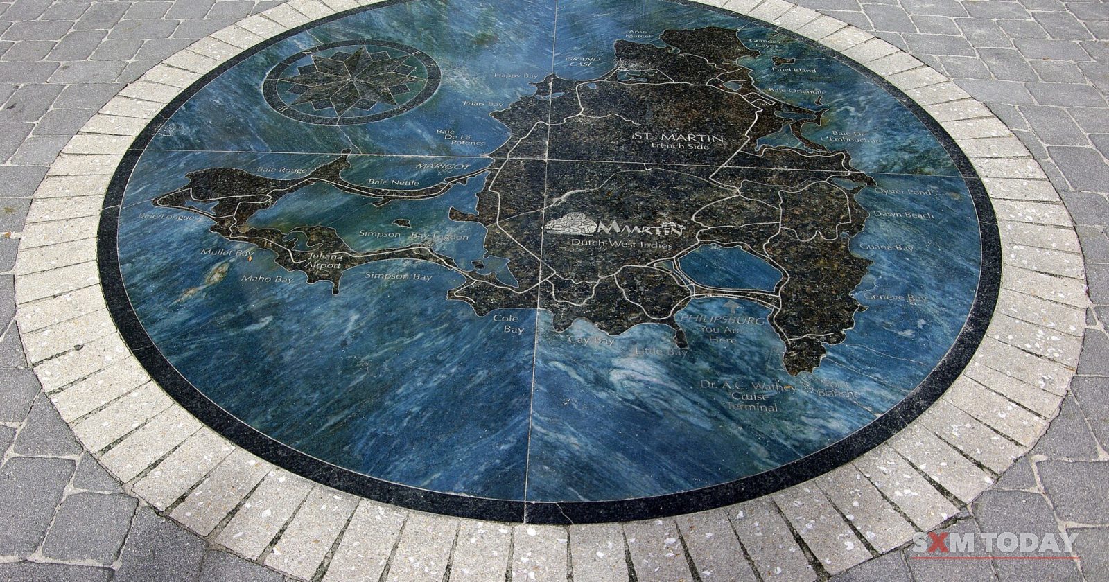 A circular stone mosaic map of the island set into a paved promenade.