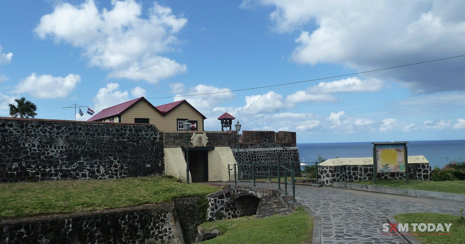 The stone walls and gateway of Fort Oranje in Oranjestad, St. Eustatius, above a cobbled path.