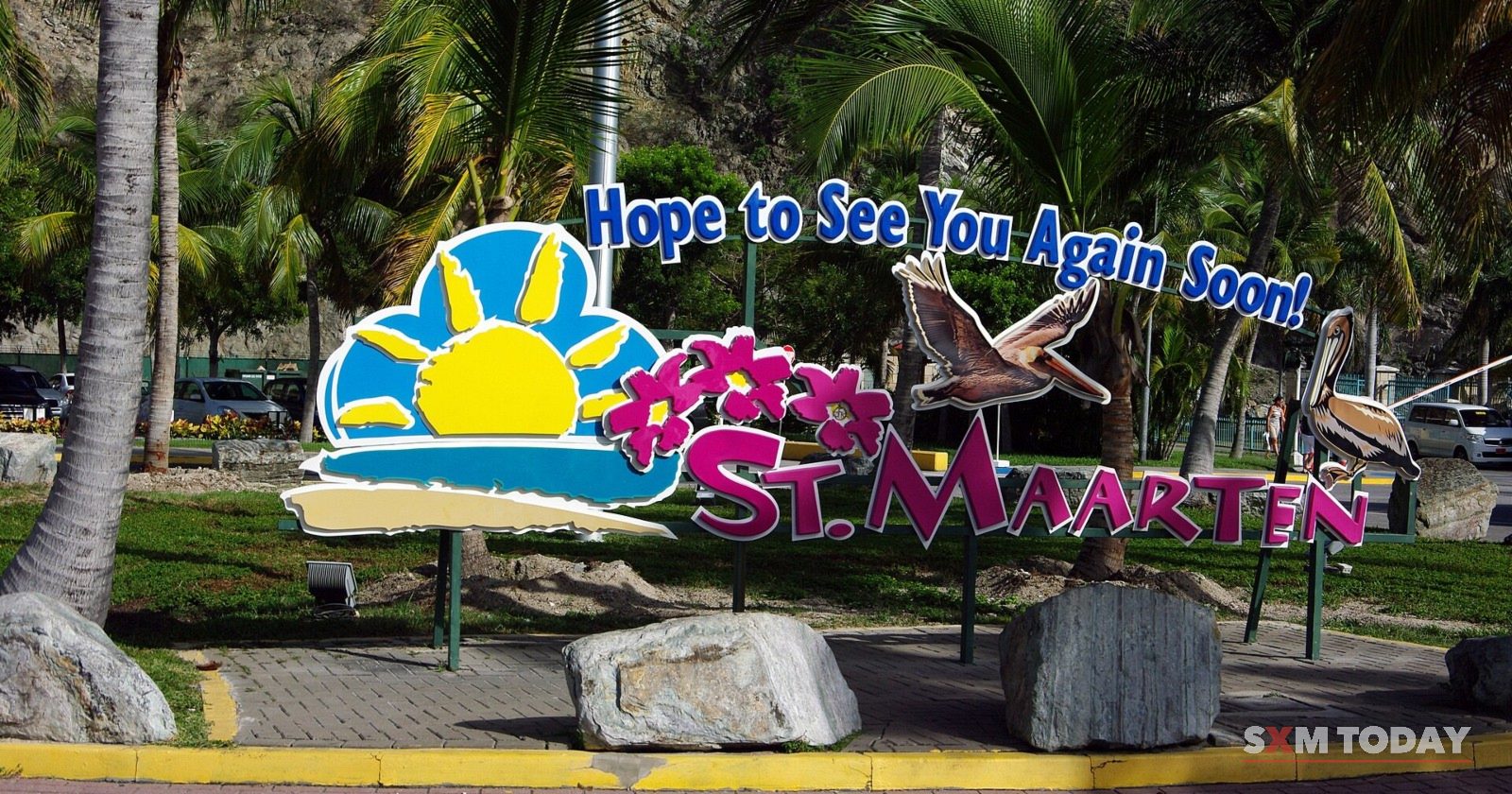 The colourful 'Hope to see you again soon, St. Maarten' sign among palms at the Philipsburg cruise terminal.