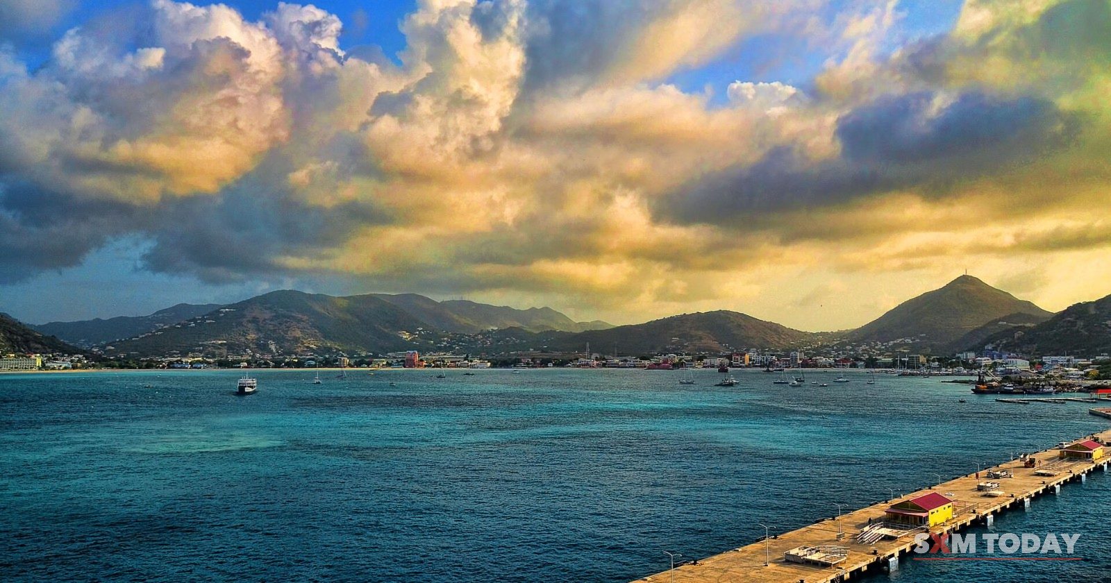 A long wooden pier reaching into Great Bay at Philipsburg under an evening sky.