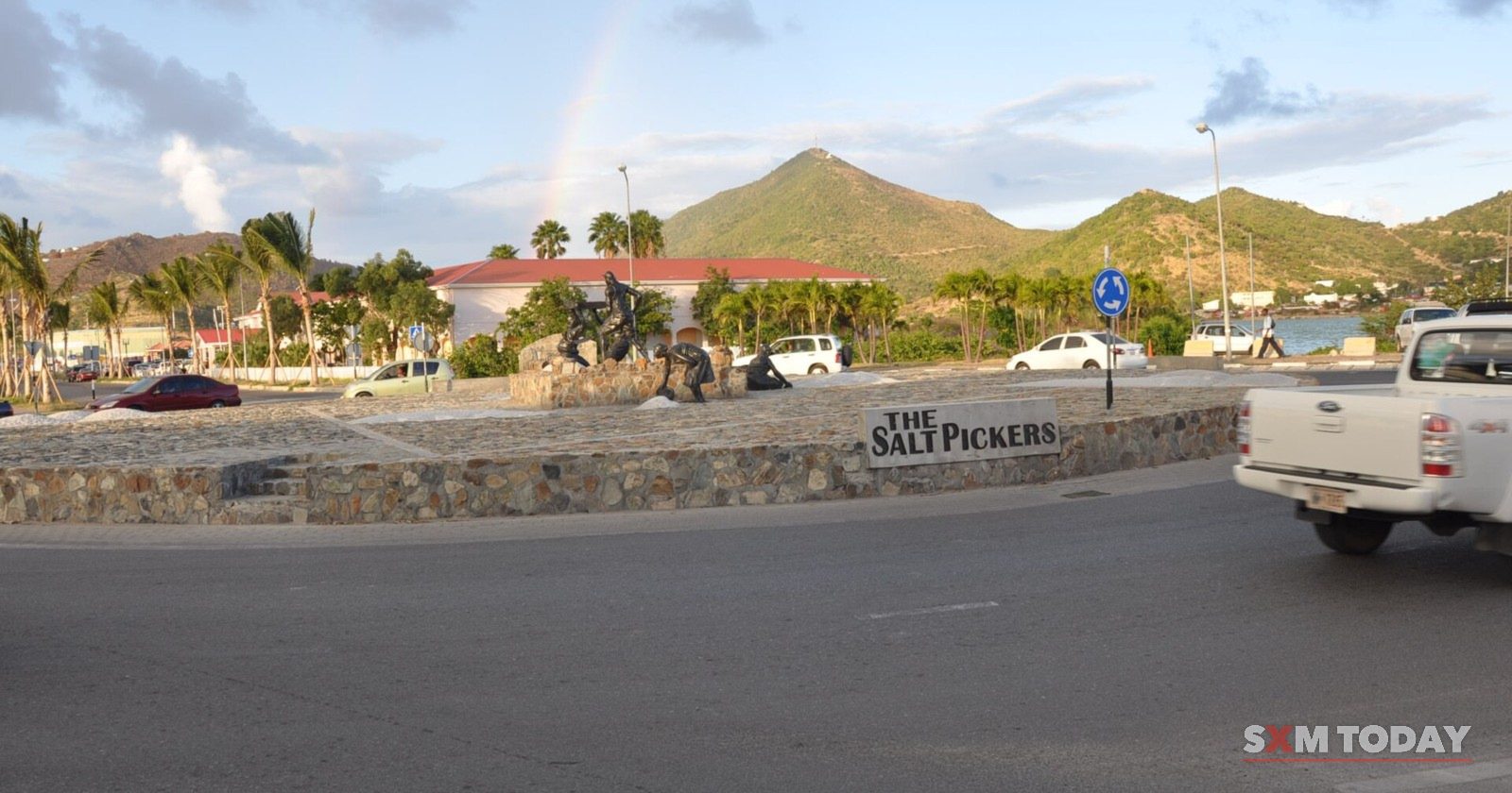 The Salt Pickers roundabout outside Philipsburg, with traffic passing and green hills behind.